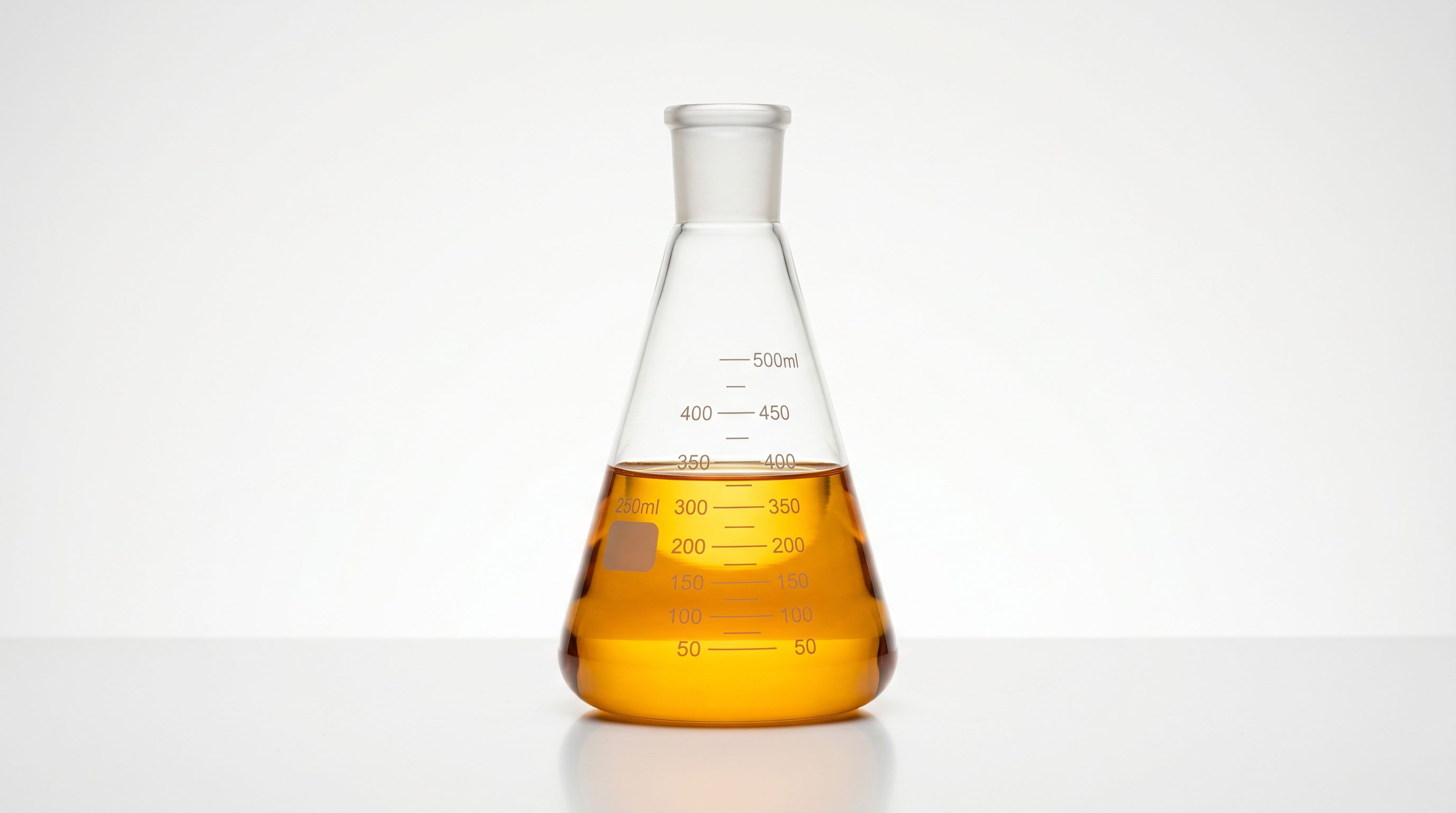 A glass laboratory flask half-filled with amber liquid, backlit with warm golden light.