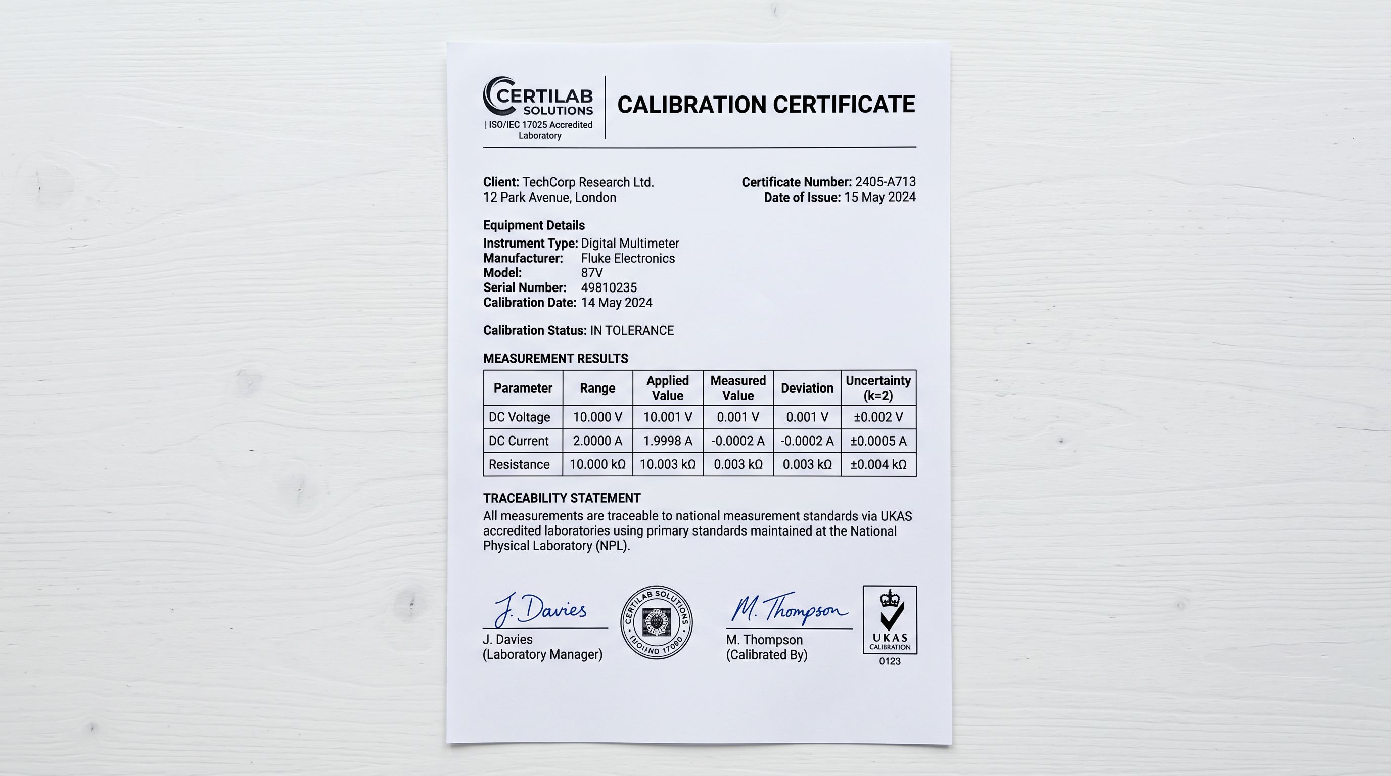A printed calibration certificate lying flat on a laboratory bench showing the certificate number, calibration date, instrument model, and a NIST-traceable measurement standard statement, sharp focus, colour photography.