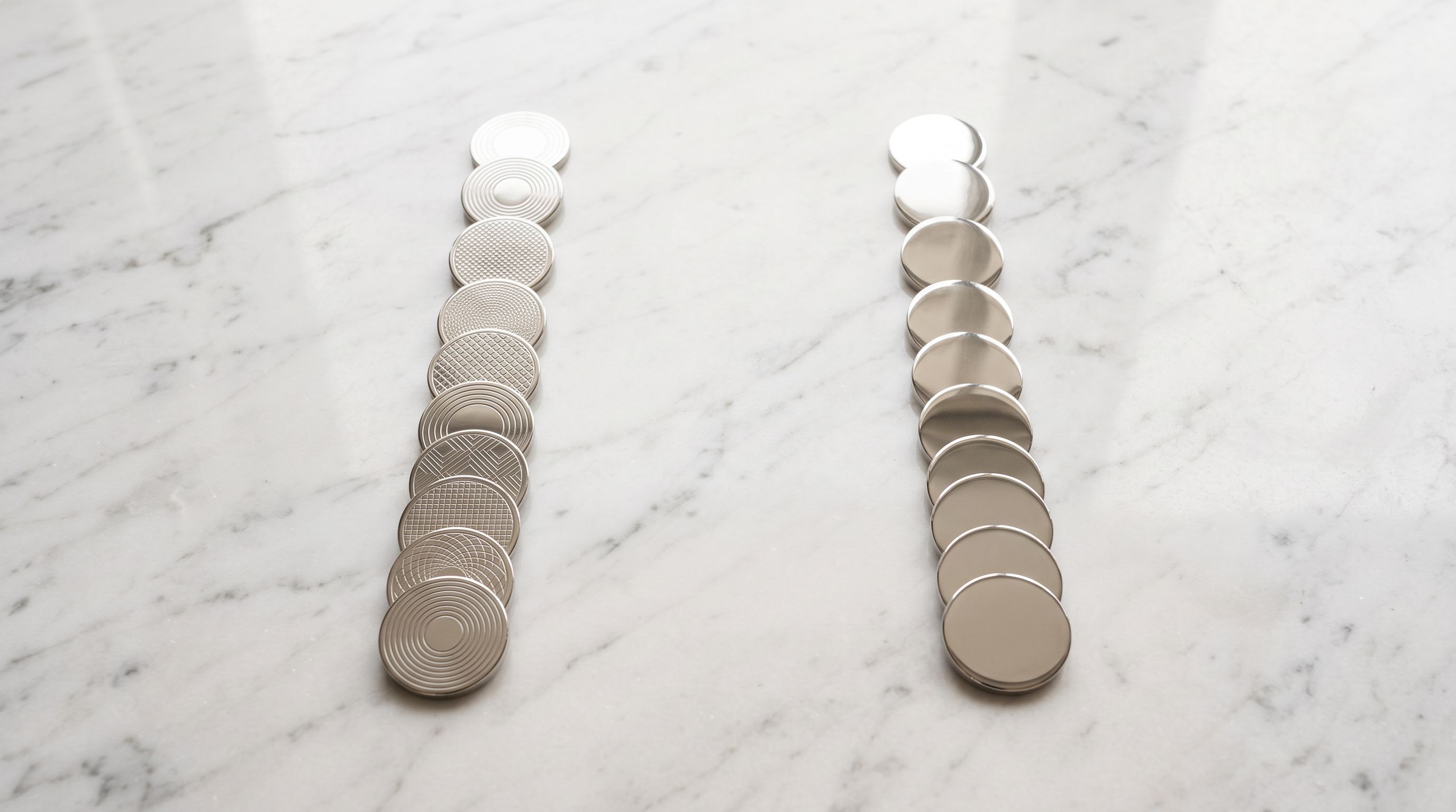 Two parallel rows of polished metal discs showing engraved and plain surfaces representing two personalisation data types.