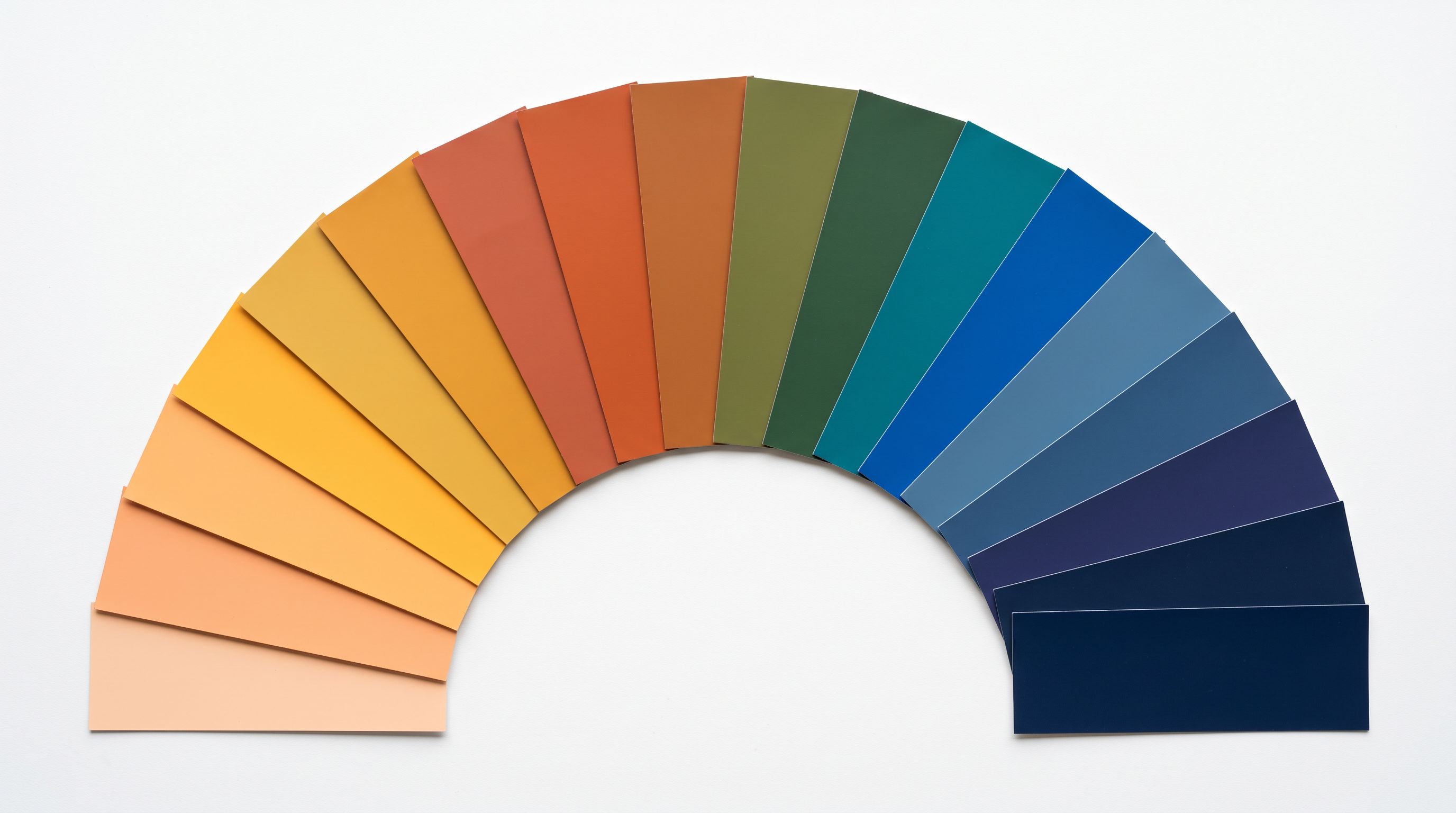 Fan of paint chip cards spread in a semi-circle showing a spectrum of colour options from warm to cool tones.