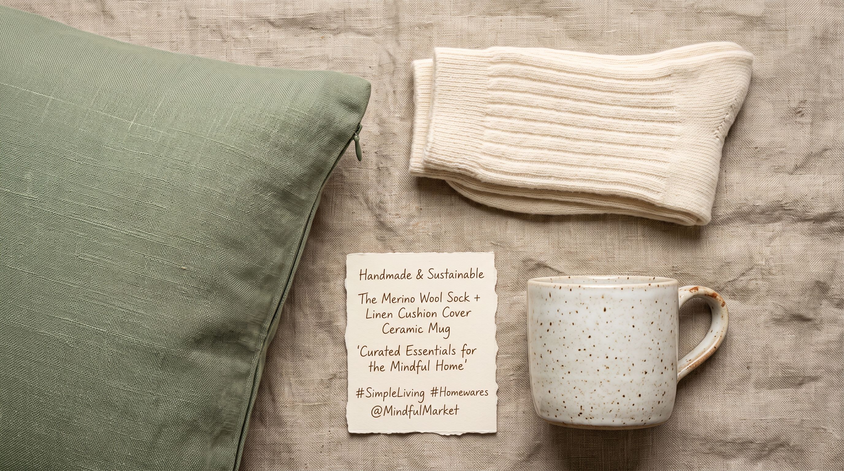Curated flatlay of lifestyle products including a merino wool sock and sage green linen cushion cover with a Pinterest-style product card on natural linen fabric