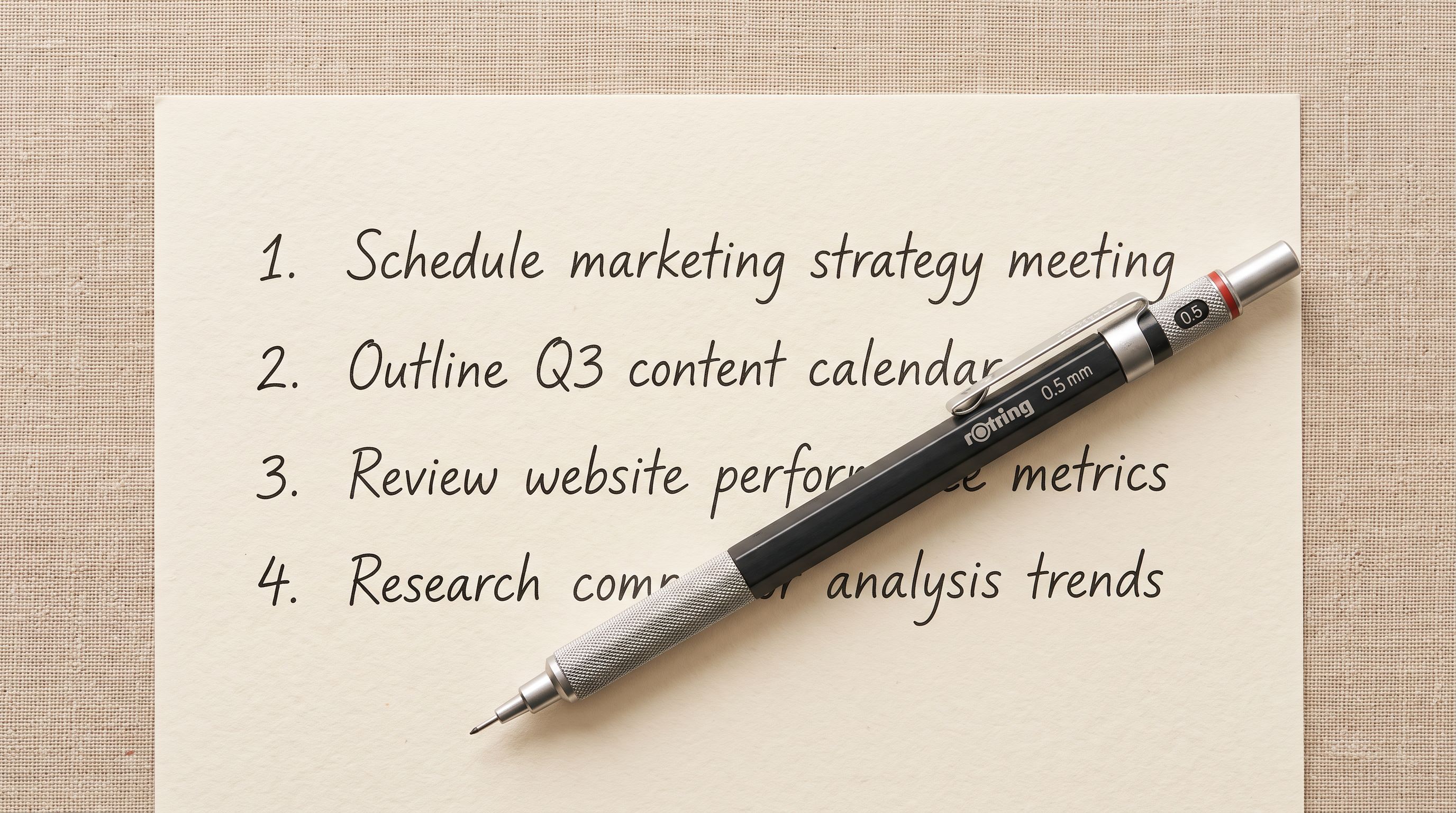 A printed numbered list on cream paper with four ordered items and a mechanical pencil resting across it.